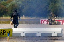 Policajt v ochrannom oblečen&iacute; kr&aacute;ča vedľa robota na zne&scaron;kodňovanie v&yacute;bu&scaron;n&iacute;n na letisku Lipsko/Halle v Schkeuditz v Nemecku (5. augusta 2026). FOTO: Reuters