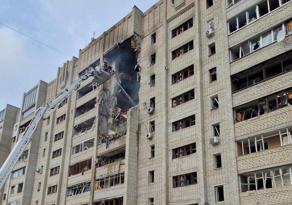 Hasiči pracuj&uacute; na mieste bytov&eacute;ho domu zasiahnut&eacute;ho rusk&yacute;m dronom v Charkove. FOTO: Reuters