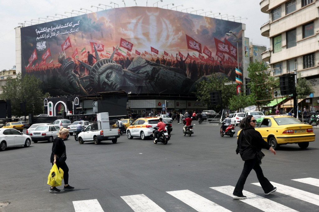 Ľudia prech&aacute;dzaj&uacute; okolo billboardu namieren&eacute;ho proti USA na ulici v Teher&aacute;ne. FOTO: Reuters