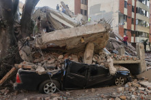 Vrak auta pod troskami zr&uacute;tenej budovy po zemetrasen&iacute; v kolumbijskom meste Cali. FOTO: TASR/AP