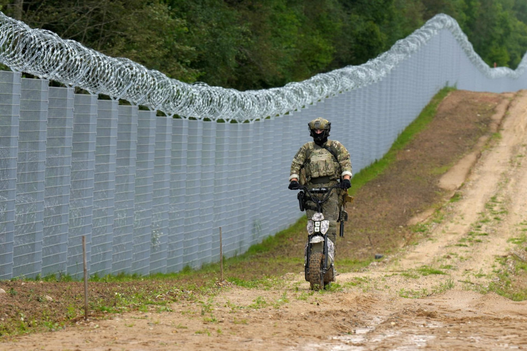 Pr&iacute;slu&scaron;n&iacute;k loty&scaron;skej &scaron;peci&aacute;lnej jednotky pohraničnej str&aacute;že hliadkuje pozdĺž plota na loty&scaron;sko-bieloruskej hranici. FOTO: Reuters