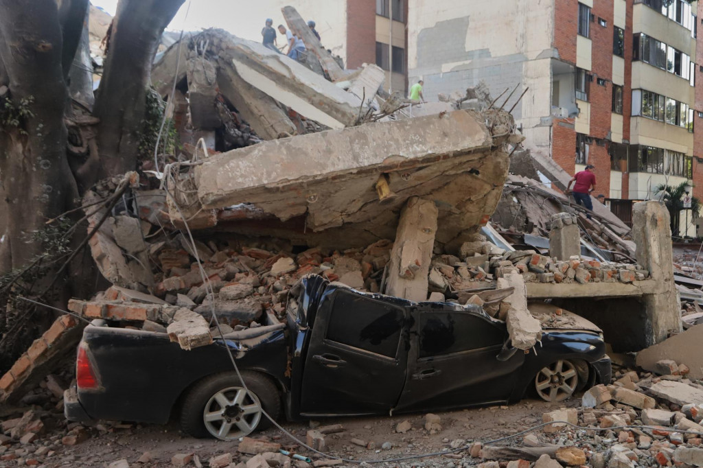 Vrak auta pod troskami zr&uacute;tenej budovy po zemetrasen&iacute; v kolumbijskom meste Cali. FOTO: TASR/AP