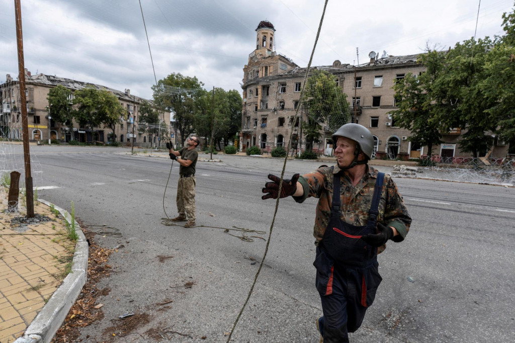 Pr&iacute;slu&scaron;n&iacute;ci ukrajinsk&yacute;ch ozbrojen&yacute;ch s&iacute;l opravuj&uacute; siete proti dronom v meste Družkivka. FOTO: Reuters/Ukrajinsk&eacute; ozbrojen&eacute; sily