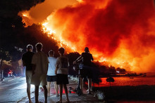 Ľudia sleduj&uacute; lesn&yacute; požiar na pobrež&iacute; Jadransk&eacute;ho mora neďaleko mesta Omi&scaron; na juhu Chorv&aacute;tska. FOTO: TASR/AP
