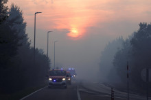 Hasičsk&eacute; vozidl&aacute; prech&aacute;dzaj&uacute; dymom uprostred lesn&eacute;ho požiaru vo Waimes v Belgicku. FOTO: Reuters