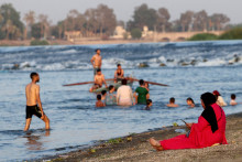 Na z&aacute;bere z 31. j&uacute;la vidno, ako sa Egyťania počas hor&uacute;čav ochladzuj&uacute; v rieke N&iacute;l, keďže drah&eacute; pr&iacute;morsk&eacute; letovisk&aacute; si nem&ocirc;žu dovoliť. FOTO: Reuters