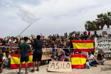 Migranti držia &scaron;panielske vlajky v Ceute. FOTO: Reuters