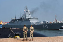 Č&iacute;nski vojaci stoja na str&aacute;ži, zatiaľ čo rusk&aacute; korveta mieri do vojensk&eacute;ho pr&iacute;stavu v Čching-tao na v&yacute;chode Č&iacute;ny, aby sa z&uacute;častnila cvičenia &bdquo;Joint Sea-2026&ldquo;. FOTO: TASR/ASP