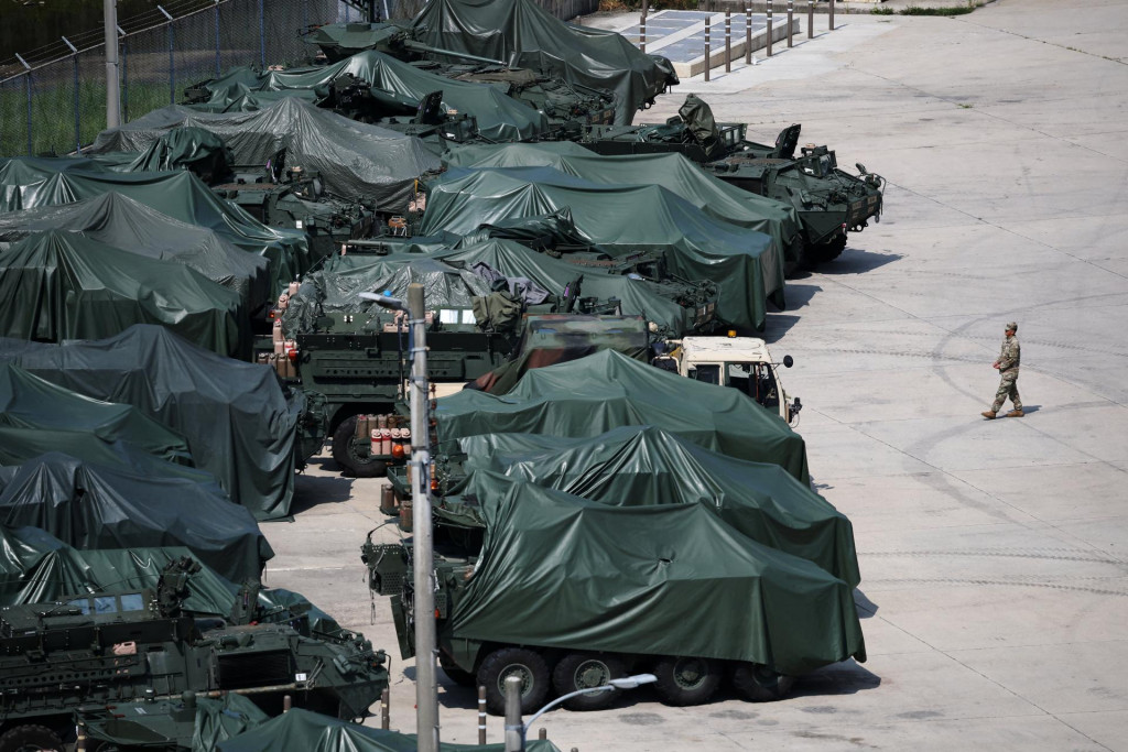 Americk&yacute; vojak prech&aacute;dza okolo obrnen&eacute;ho vozidla Stryker pokryt&eacute;ho plachtou na z&aacute;kladni americkej arm&aacute;dy neďaleko demilitarizovanej z&oacute;ny oddeľuj&uacute;cej dve K&oacute;rey. FOTO: REUTERS