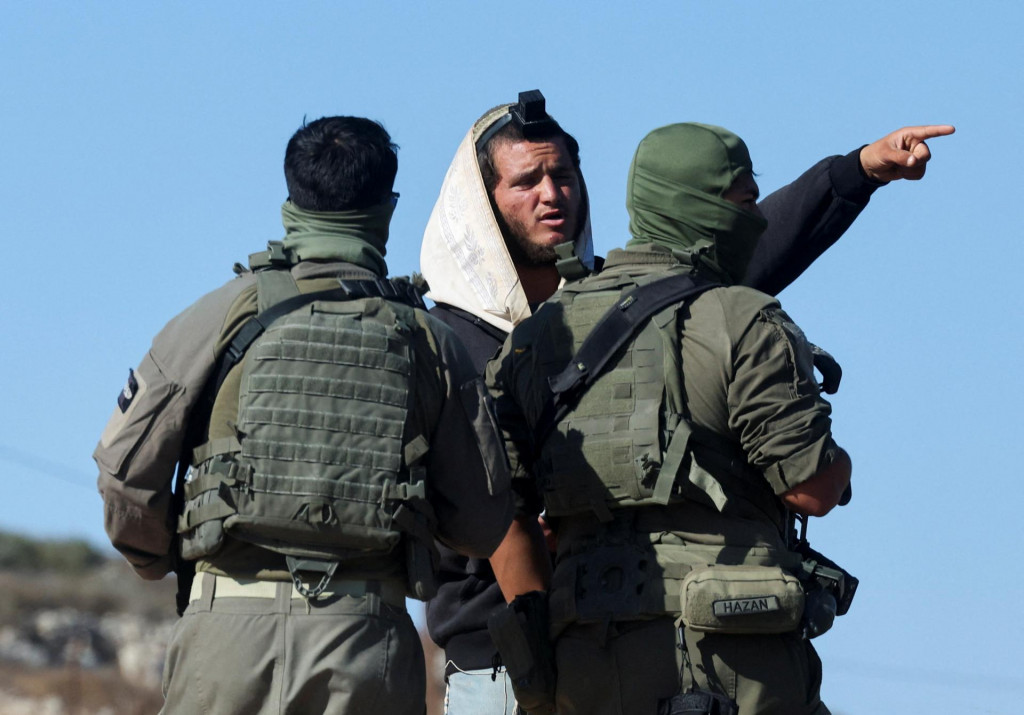 Izraelsk&iacute; vojaci sa rozpr&aacute;vaj&uacute; s izraelsk&yacute;m osadn&iacute;kom. FOTO: Reuters