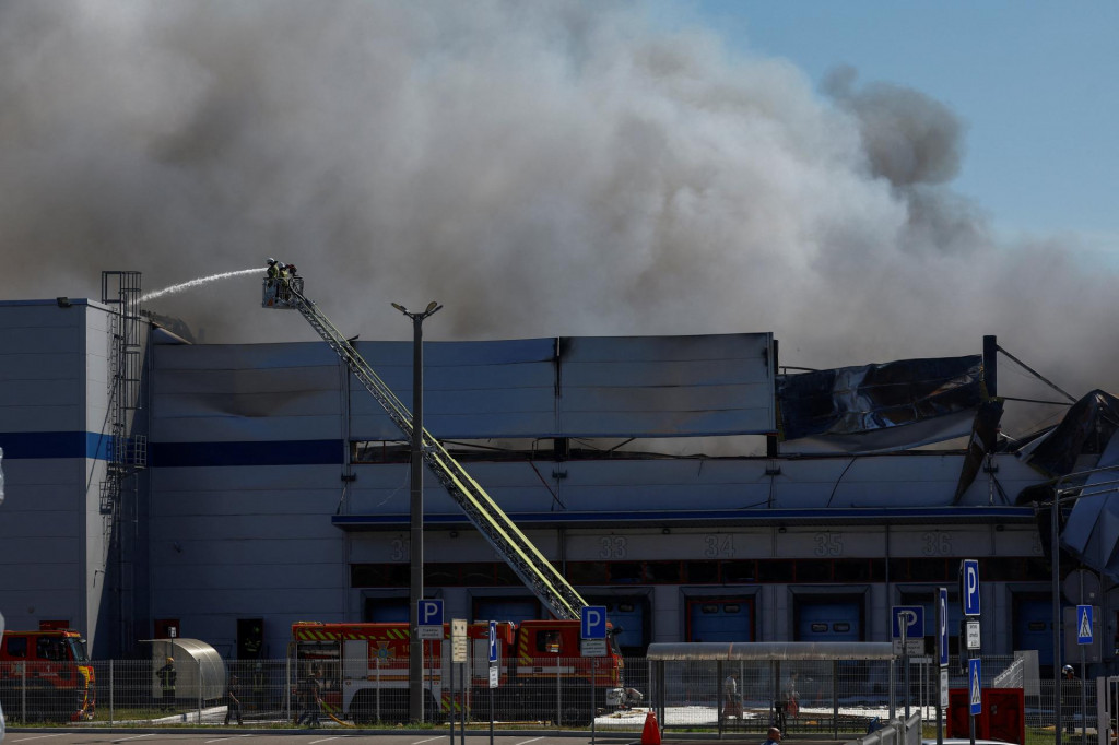 Hasiči pracuj&uacute; na mieste skladu zasiahnut&eacute;ho rusk&yacute;m dronom v Kyjevskej oblasti na Ukrajine. FOTO: Reuters