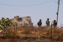 Izraelsk&iacute; vojaci stoja pri palest&iacute;nskom dome, ktor&yacute; obliehali izraelsk&iacute; osadn&iacute;ci v dedine Kusra na Izraelom okupovanom Z&aacute;padnom brehu Jord&aacute;nu. FOTO: Reuters