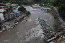Zlomen&yacute; most a po&scaron;koden&eacute; domy po bleskov&yacute;ch povodniach a zosuvoch p&ocirc;dy v Devighate v okrese Nuwakot v Nep&aacute;le. FOTO: Reuters