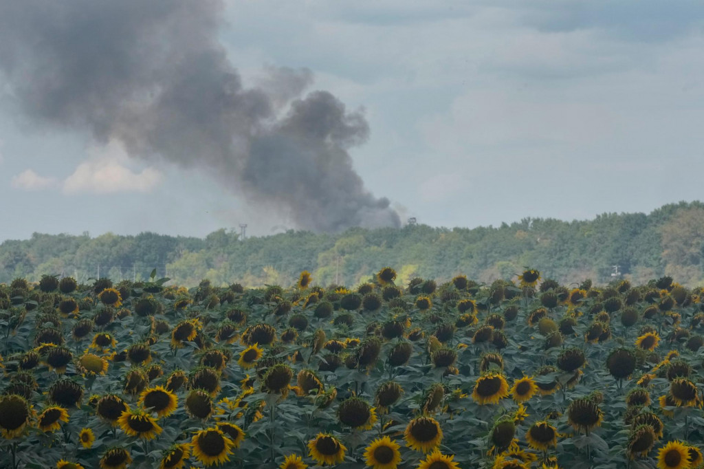 Dym st&uacute;pa nad skladov&yacute;mi halami za poľom slnečn&iacute;c po leteckom &uacute;toku ruskej arm&aacute;dy na Kyjev. FOTO: TASR/AP