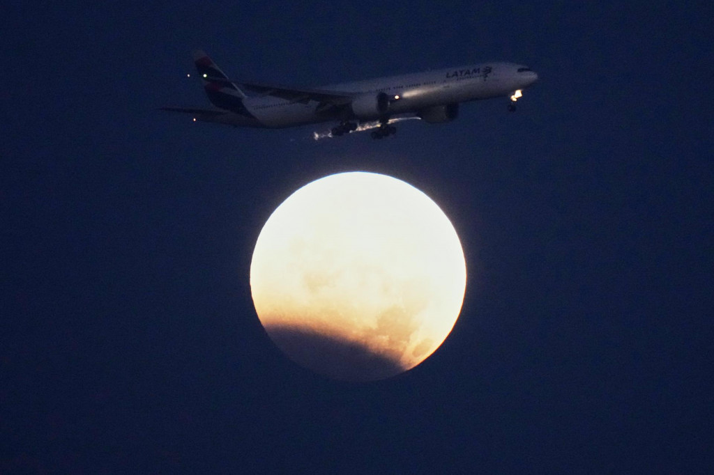 Lietadlo Boeing 777 leteckej spoločnosti LATAM let&iacute; počas čiastočn&eacute;ho zatmenia Mesiaca nad Portugalskom 28. augusta.
