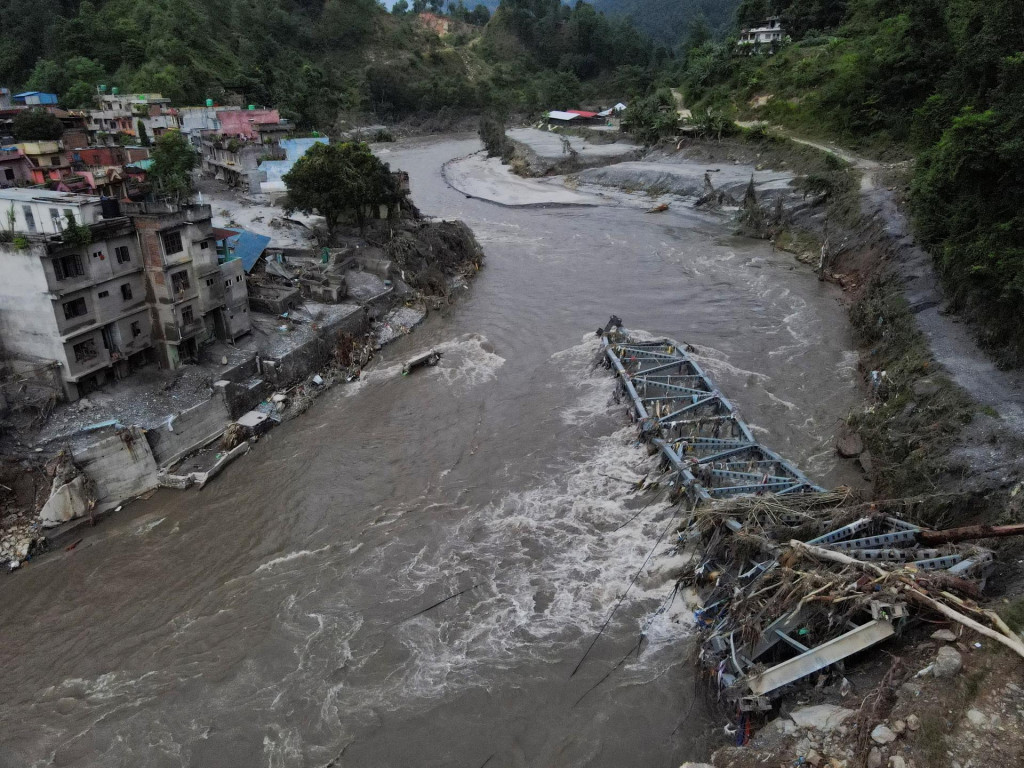 Zlomen&yacute; most a po&scaron;koden&eacute; domy po bleskov&yacute;ch povodniach a zosuvoch p&ocirc;dy v Devighate v okrese Nuwakot v Nep&aacute;le. FOTO: Reuters