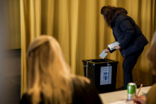 Žena vhadzuje hlasovac&iacute; l&iacute;stok do schr&aacute;nky počas referenda v Reykjav&iacute;ku. FOTO: TASR/AP