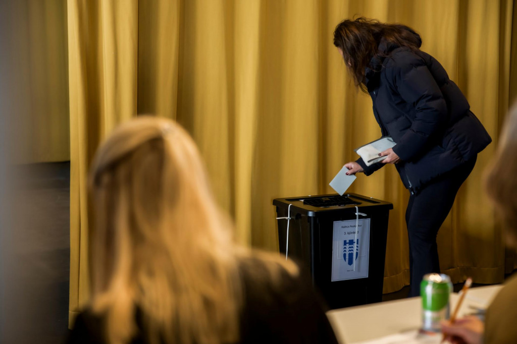 Žena vhadzuje hlasovac&iacute; l&iacute;stok do schr&aacute;nky počas referenda v Reykjav&iacute;ku. FOTO: TASR/AP