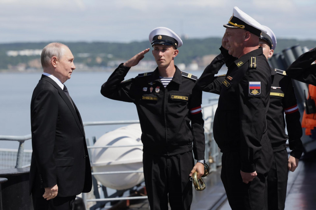 Rusk&yacute; prezident Vladimir Putin (vľavo) stoj&iacute; na palube rusk&eacute;ho raketov&eacute;ho kr&iacute;žnika Varjag, aby sledoval vojensk&eacute; cvičenie pri meste Južno-Sachalinsk na ostrove Sachalin, na ruskom Ďalekom v&yacute;chode.