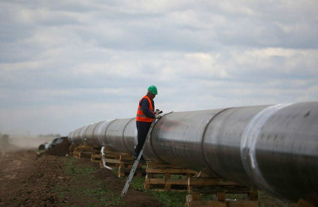Robotn&iacute;k stoj&iacute; vedľa potrubia na stavenisku pri predĺžen&iacute; plynovodu TurkStream. FOTO: Reuters