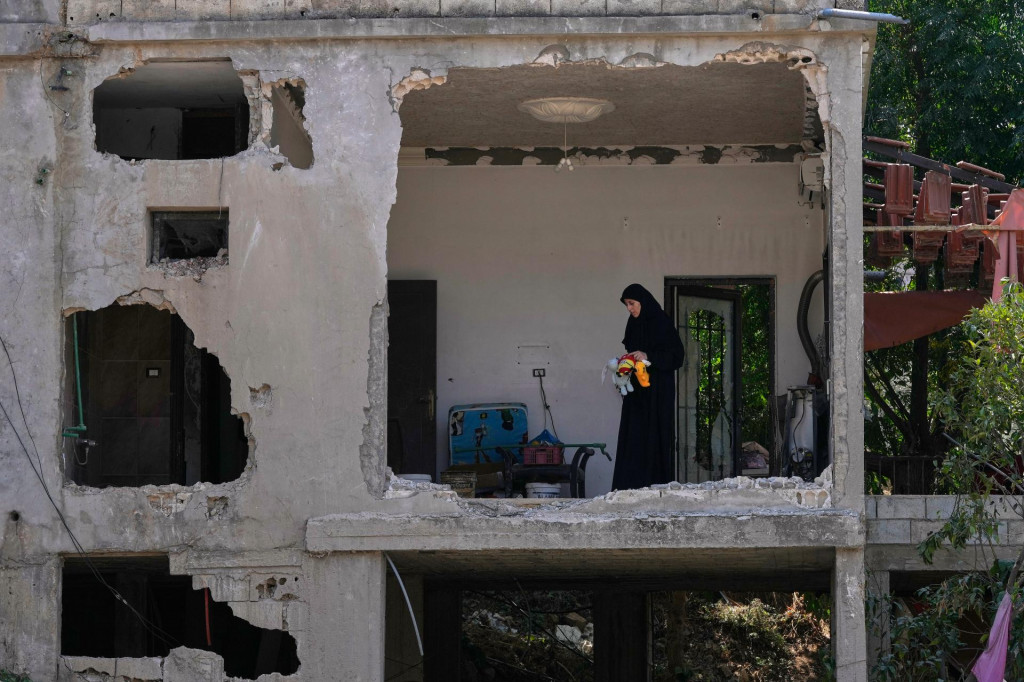 Žena kontroluje trosky zničen&eacute;ho domu na mieste, ktor&eacute; zasiahla raketa po izraelsk&yacute;ch leteck&yacute;ch &uacute;tokoch v dedine Arab Sal&iacute;m, na juhu Libanonu. FOTO: TASR/AP
