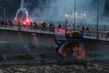 Podporovatelia zosnul&eacute;ho bosnianskosrbsk&eacute;ho gener&aacute;la Ratka Mladića držia jeho obraz a zapaľuj&uacute; svetlice na Varadinskom moste v Novom Sade v Srbsku. FOTO: Reuters