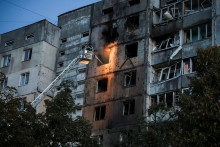Ukrajinsk&iacute; hasič&iacute; zasahuj&uacute; pri požiari bytovky v Kyjeve po ruskom dronovom &uacute;toku. FOTO: Reuters