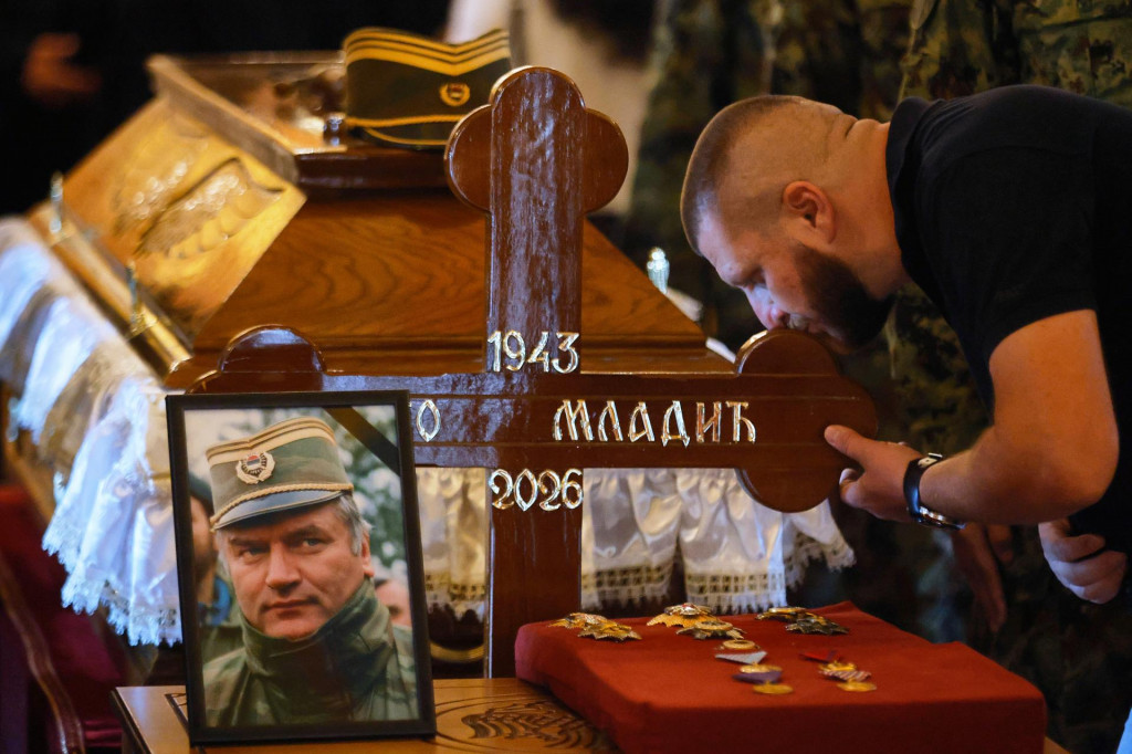 Muž bozk&aacute;va kr&iacute;ž na truhle vojnov&eacute;ho zločinca Ratka Mladiča počas jeho pohrebu v Belehrade. FOTO: TASR/AP